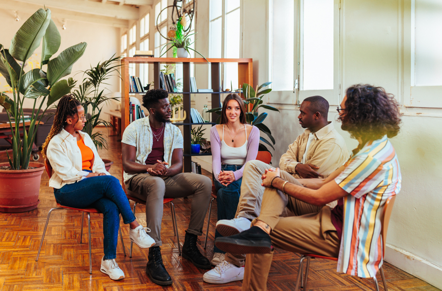 Five diverse young people on group therapy session